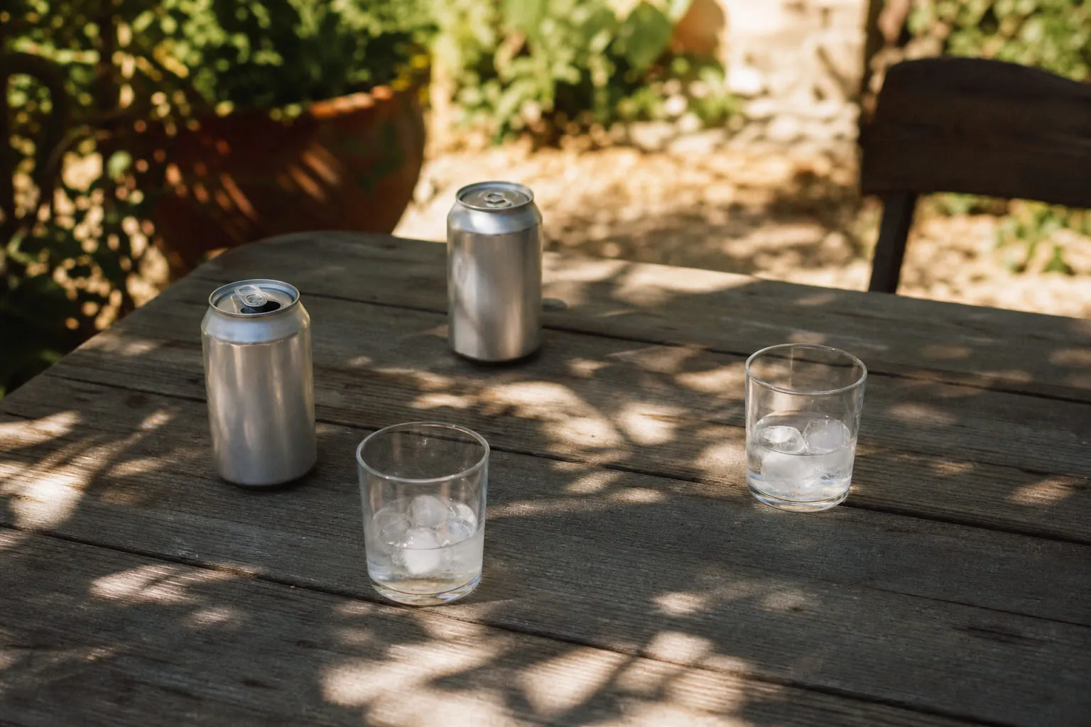 Deux canettes neutres et des verres avec glaçons sur un comptoir