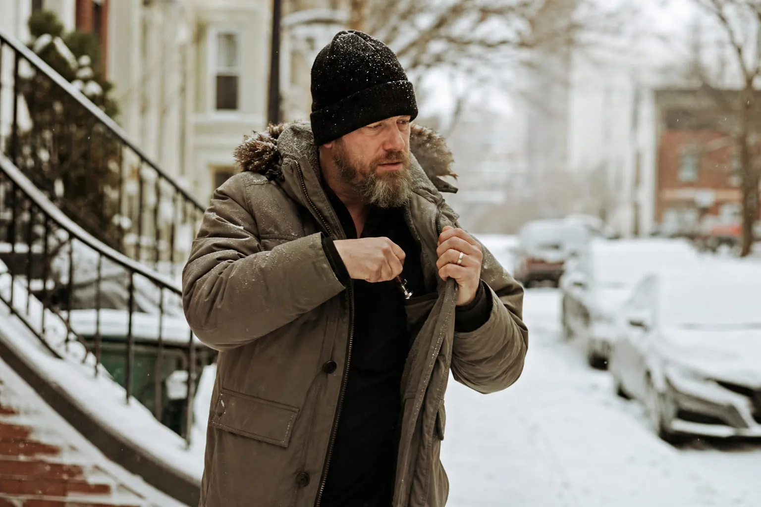Homme en manteau d'hiver glissant sa cigarette électronique dans sa poche intérieure