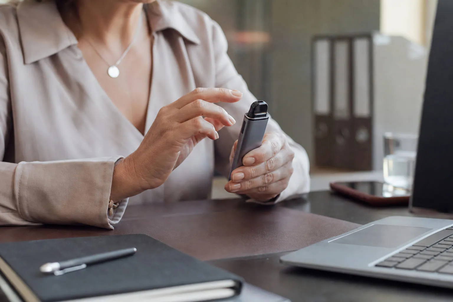 Main vérifiant du bout des doigts la température d'une box de vape