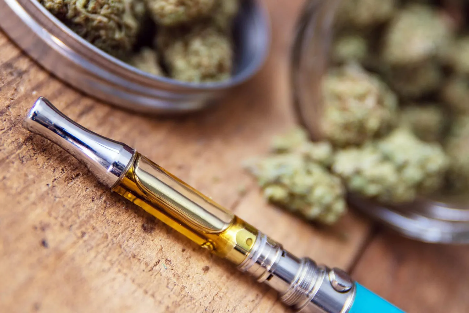 Un flacon de e-liquide au CBD posé à côté d'un pod sur une table