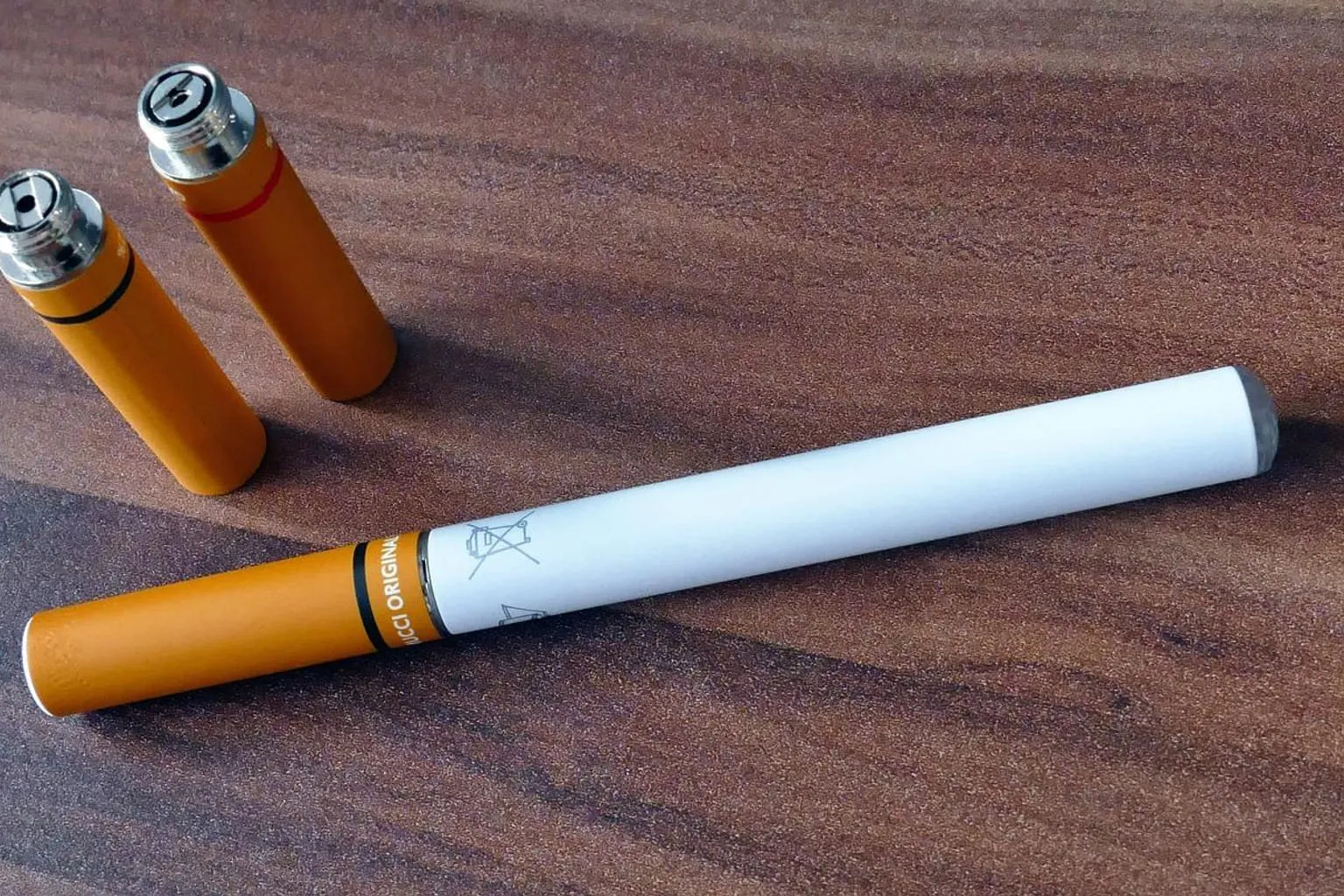 Une cigarette électronique au fini soigné posée sur un plateau sombre