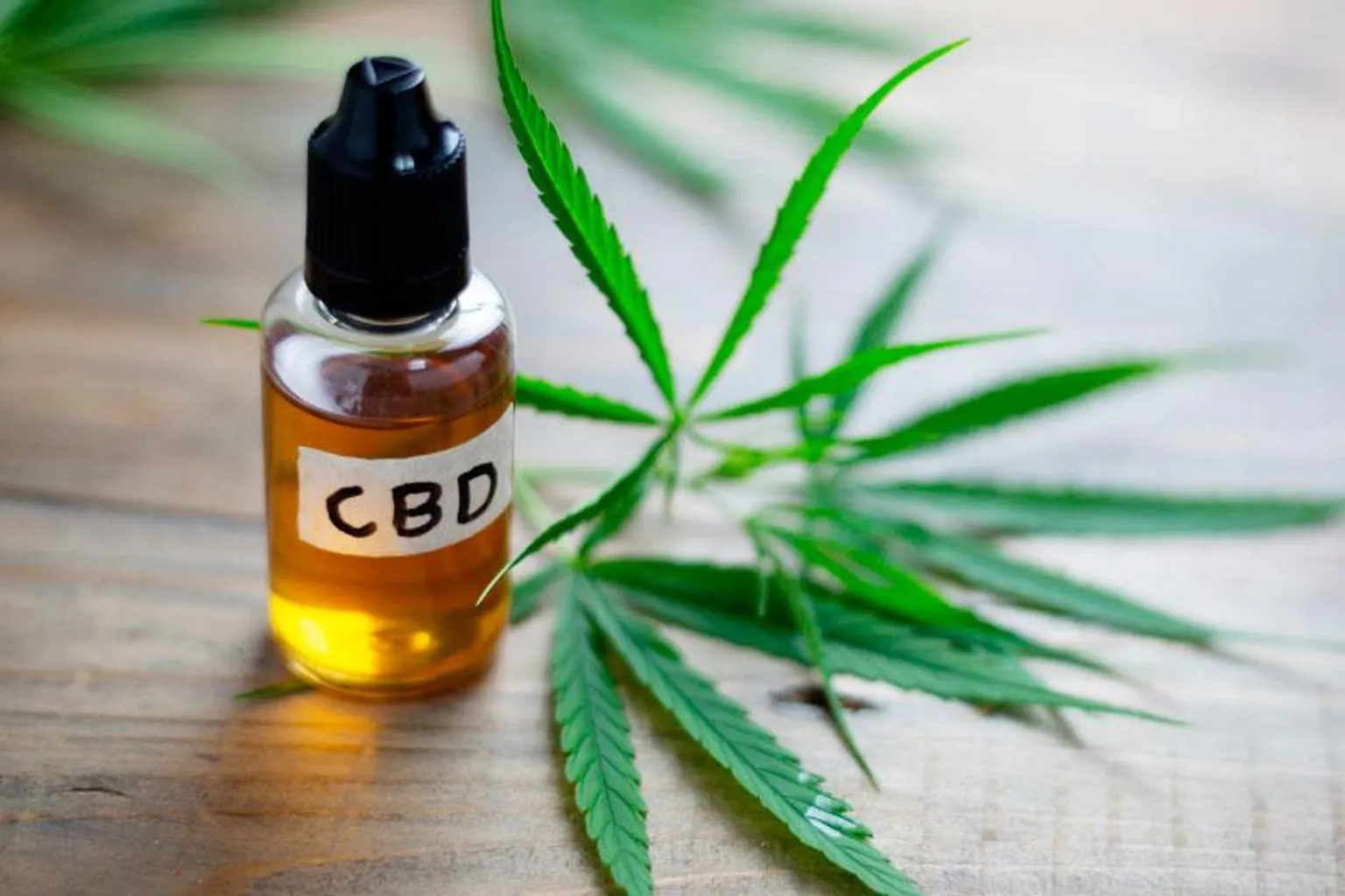 Documents et flacon de CBD posés sur un bureau