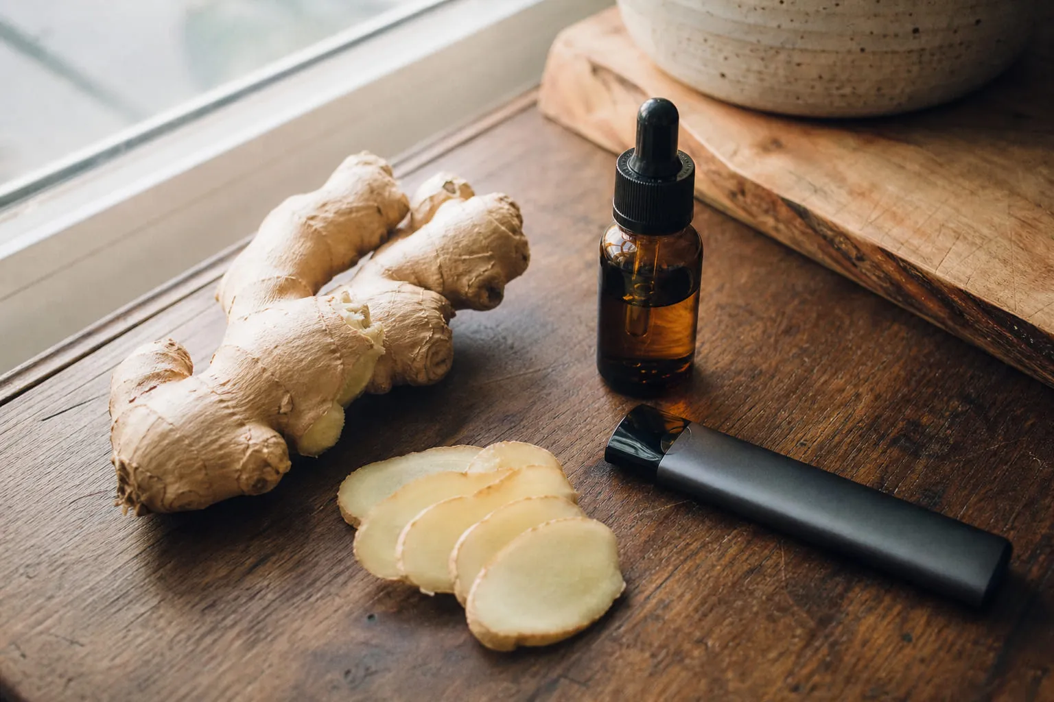 Rhizome de gingembre frais et tranches fines sur une planche