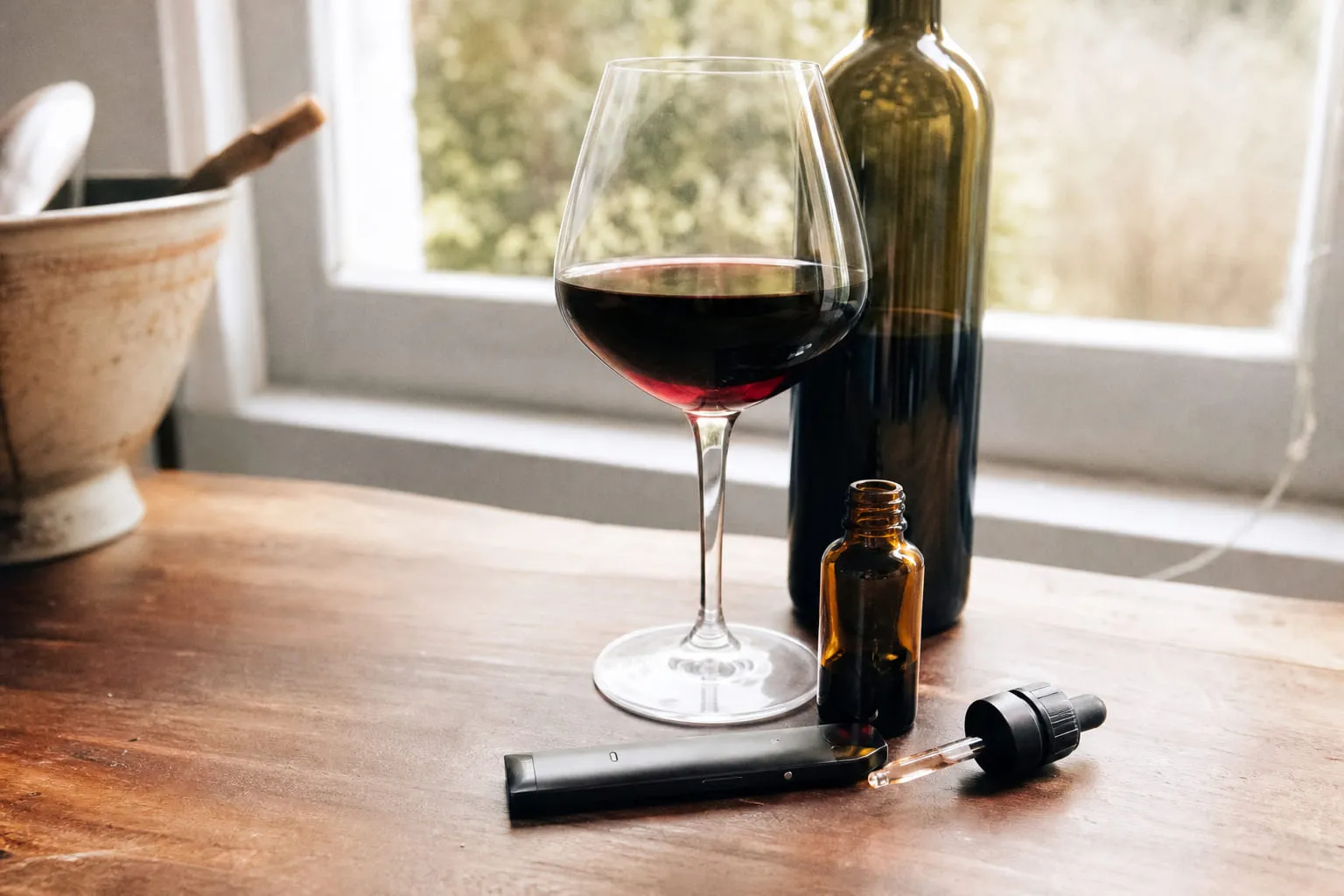 Verre de vin rouge et bouteille sans étiquette sur une table