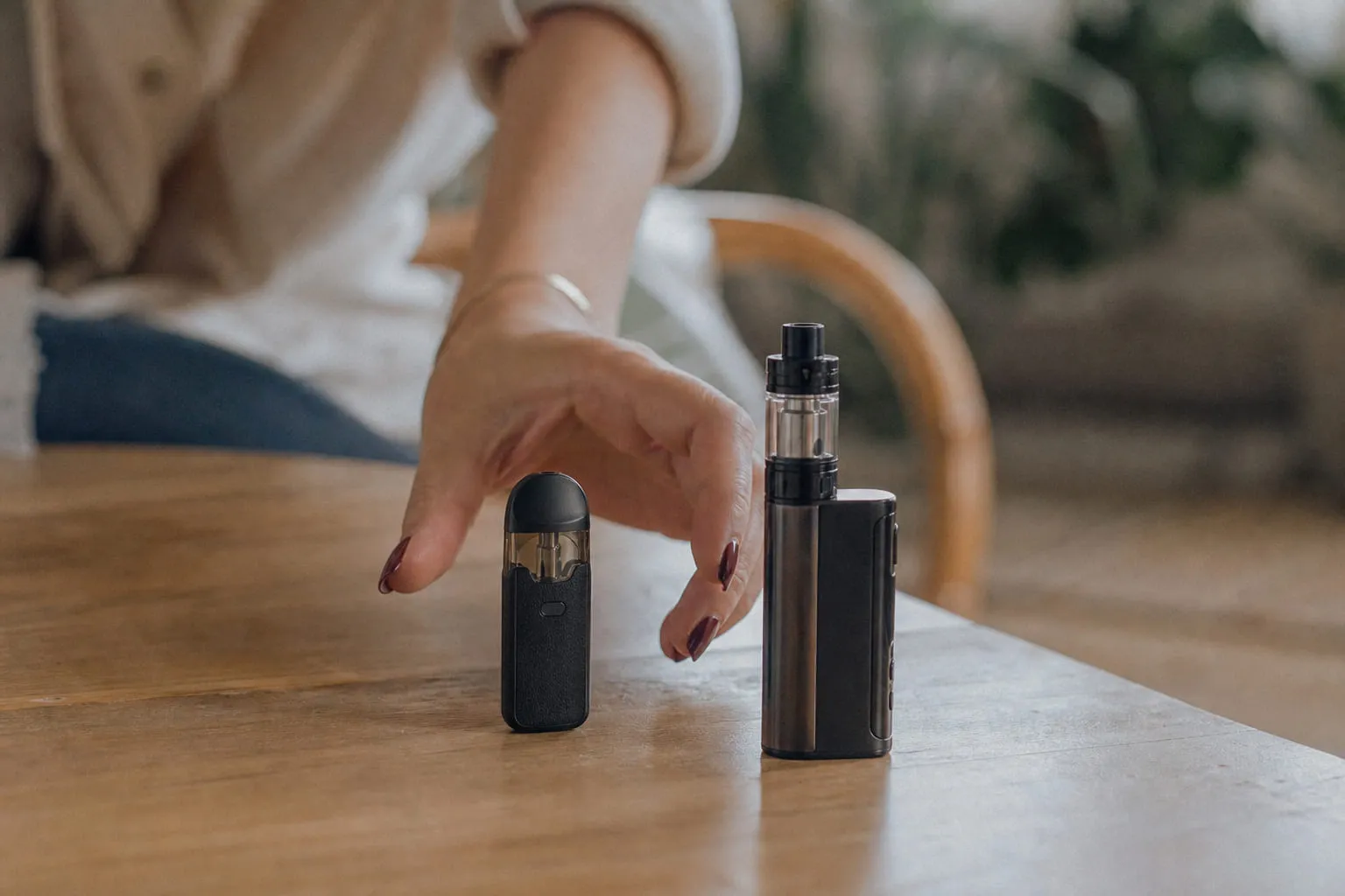 Pod compact et box de vape posés côte à côte sur une table en bois clair