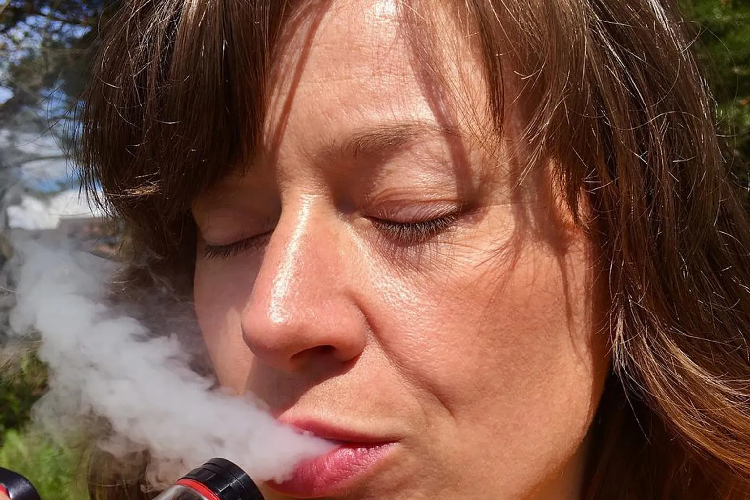 Flacon de e-liquide avec compte-gouttes posé près d'un carnet de notes