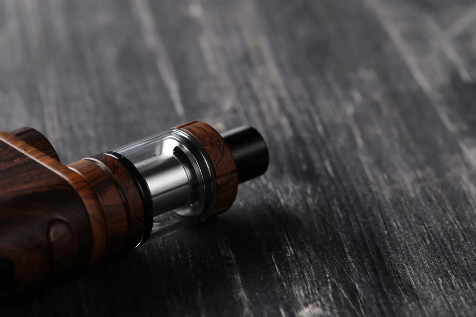Écran d'une box de vape affichant des réglages, doigt sur le bouton