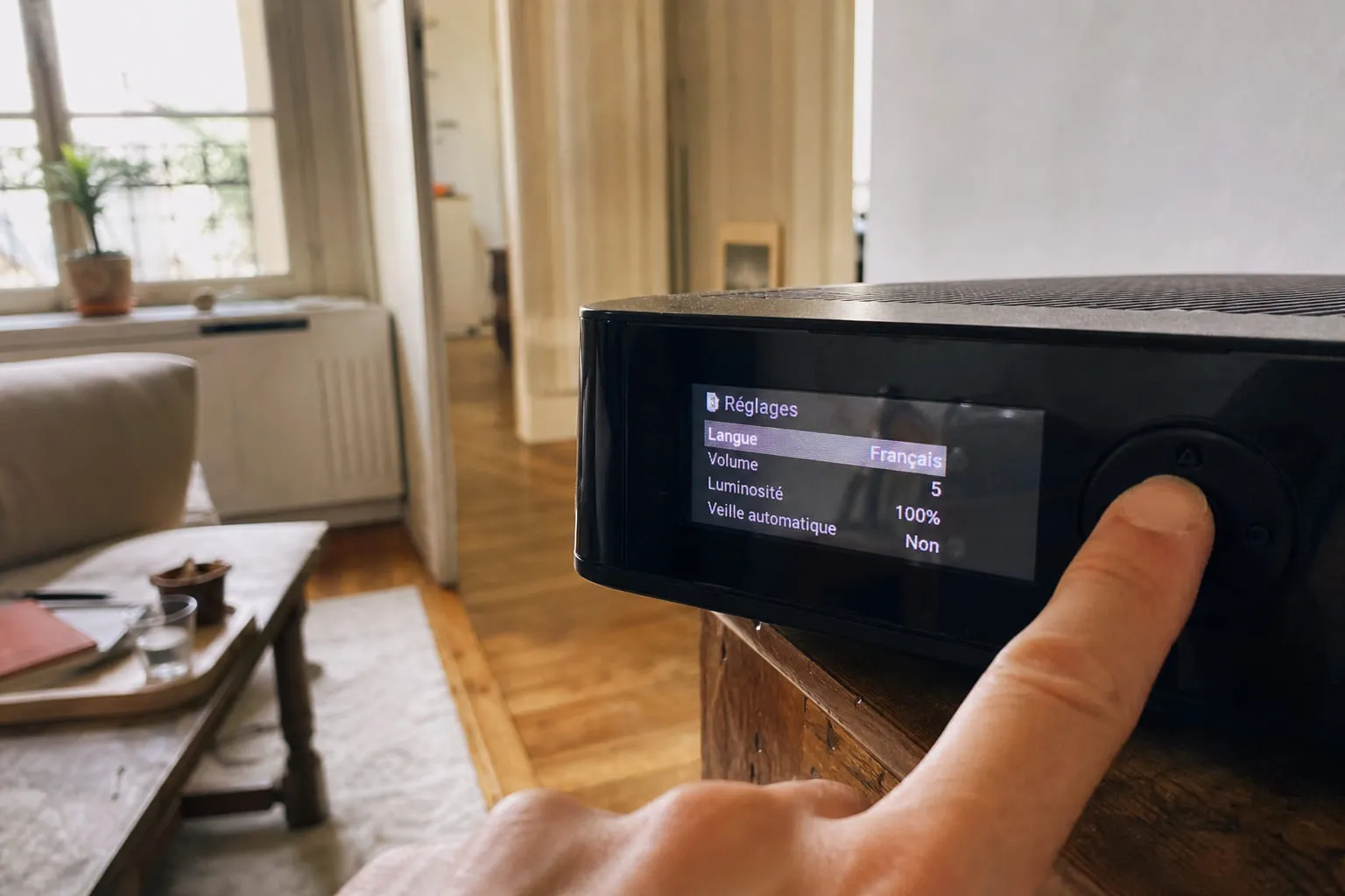 Écran d'une box affichant des réglages, doigt appuyant sur le bouton