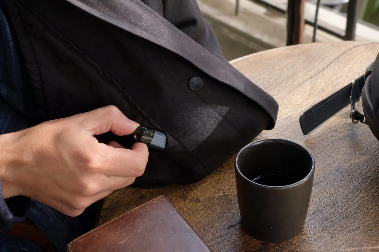 Un petit pod glissé dans la poche d'une veste, sorti à la main