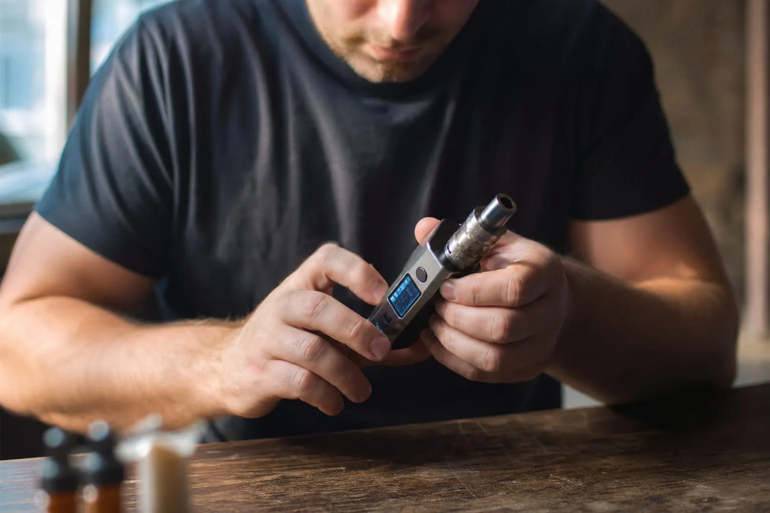 Flacons de e-liquide alignés sur une étagère avec un carnet de suivi